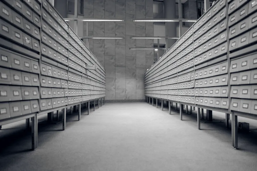Reihen beschrifteter Archivkästen in einem Aktenlager